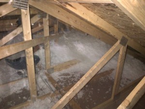 attic install of loose-fill fiberglass